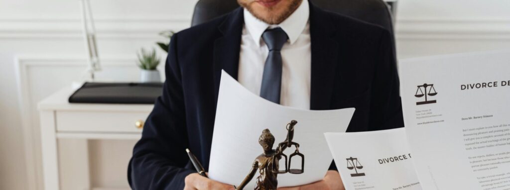 Legal professionals reviewing divorce documents in a law office with a Lady Justice statue.